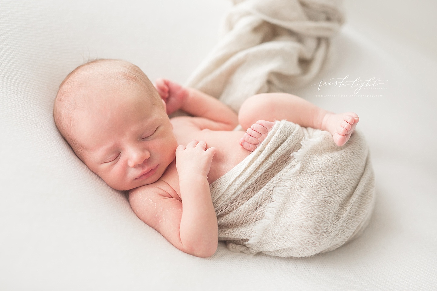 newborn wrapped with feet out
