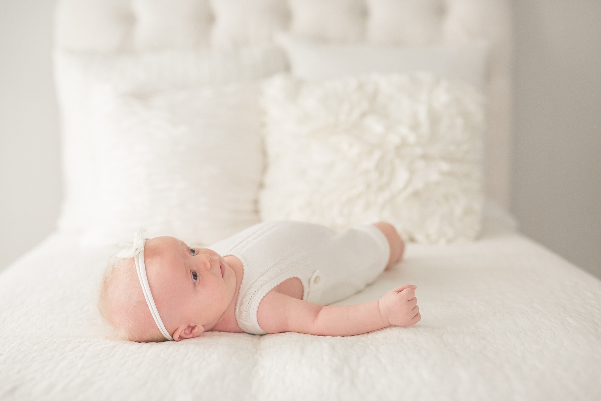 1 month old baby laying on a bed