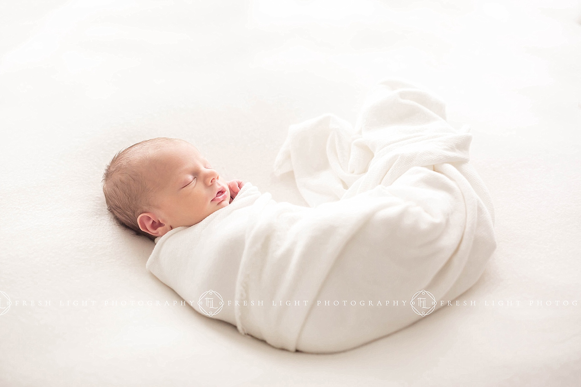 Baby swaddled with white captured by houston newborn photographer fresh light photography