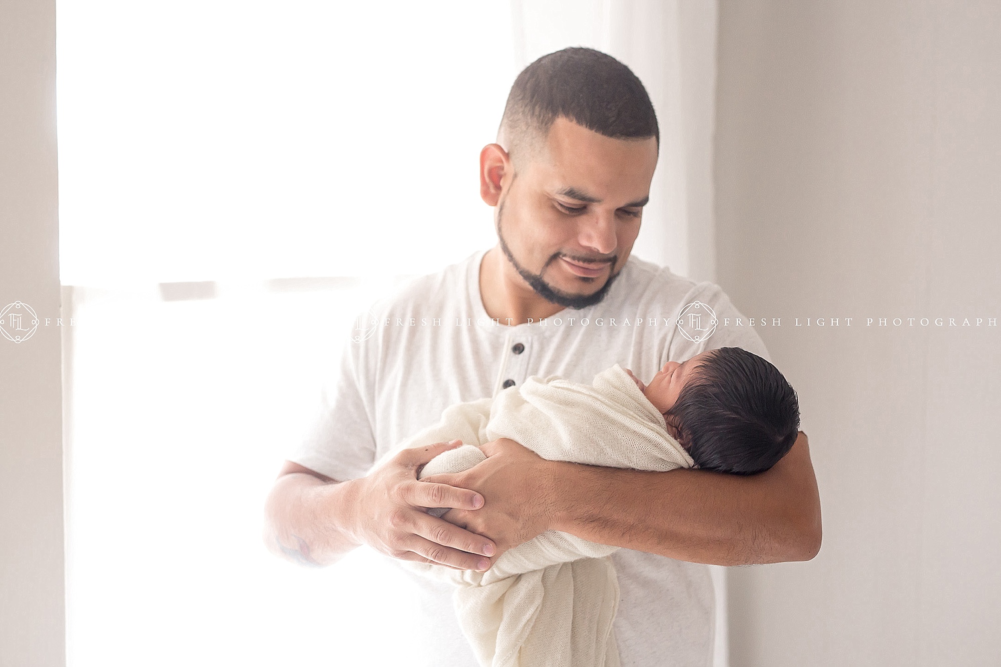 Dad standing in natural light with newborn at houston photography session