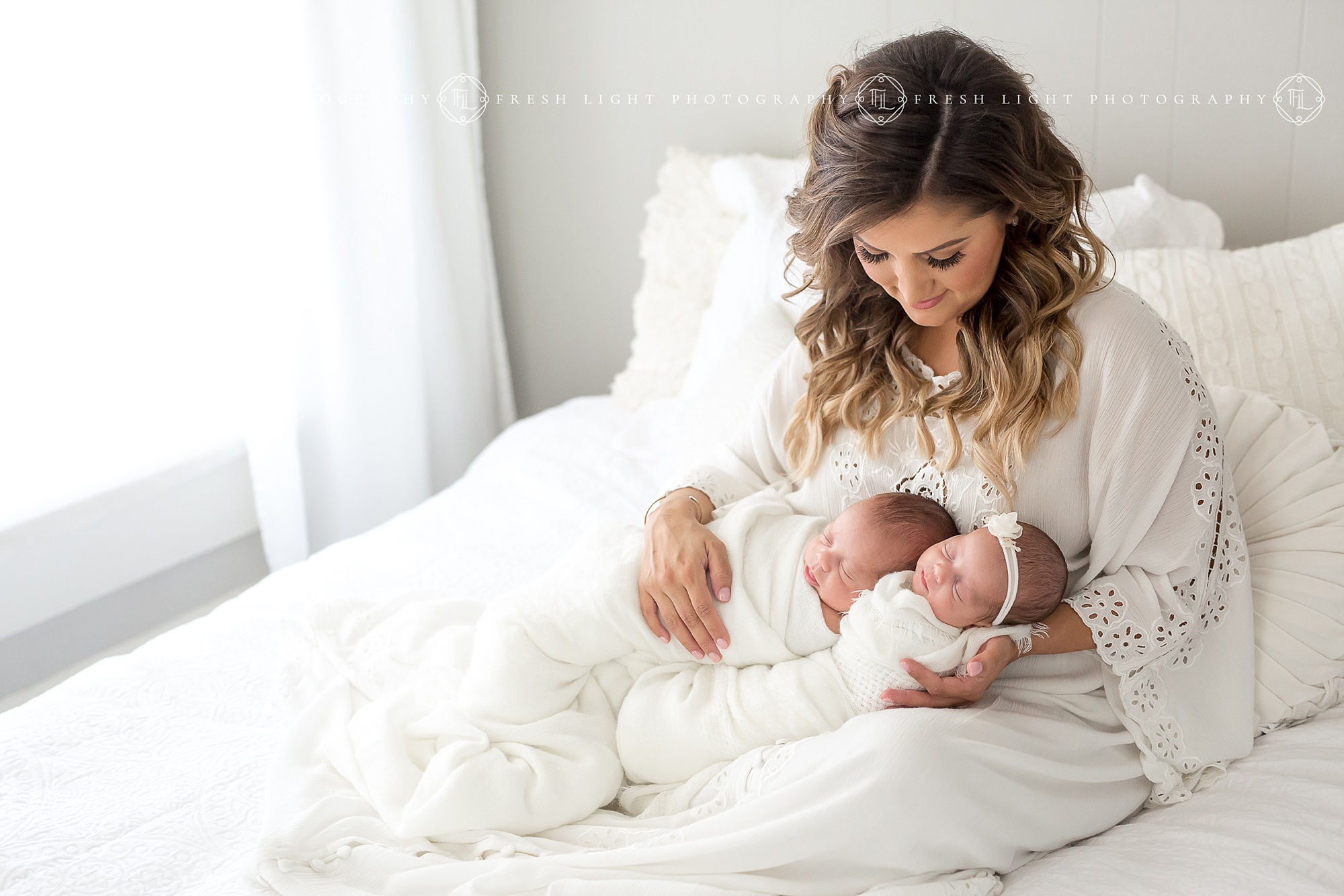 Mom holding newborn twins in Houston Photography Studio
