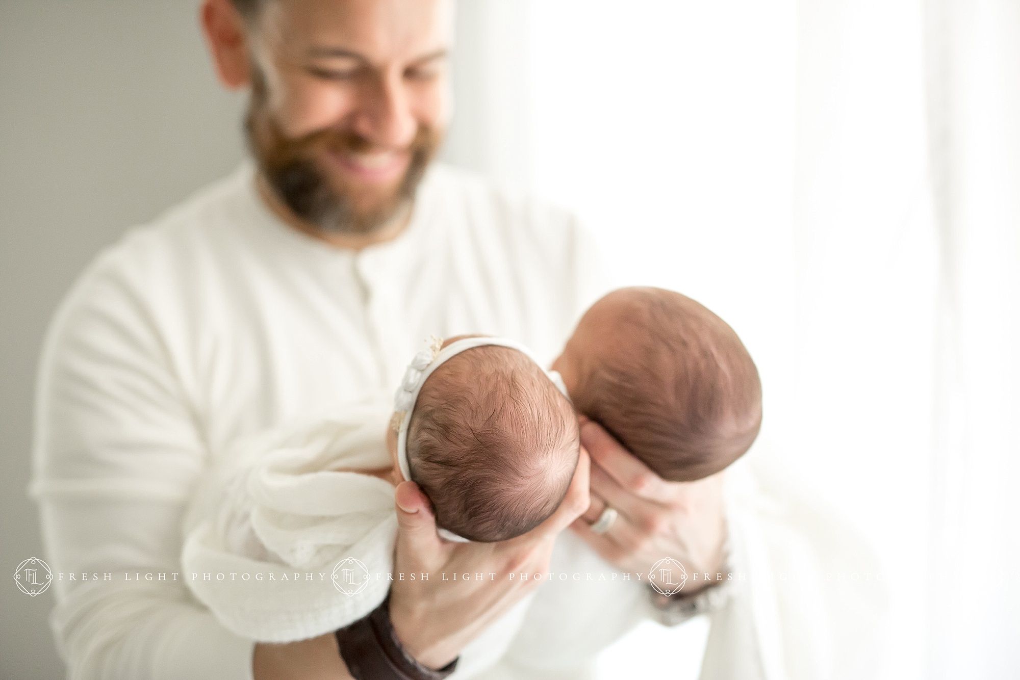 Dad holding Newborn Twins in Houston Photography Studio