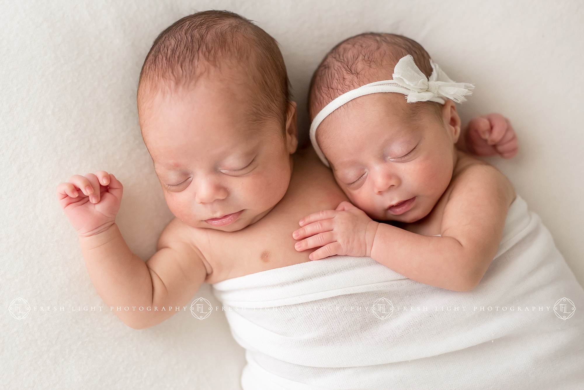 Newborn twins holding each other in Houston Studio