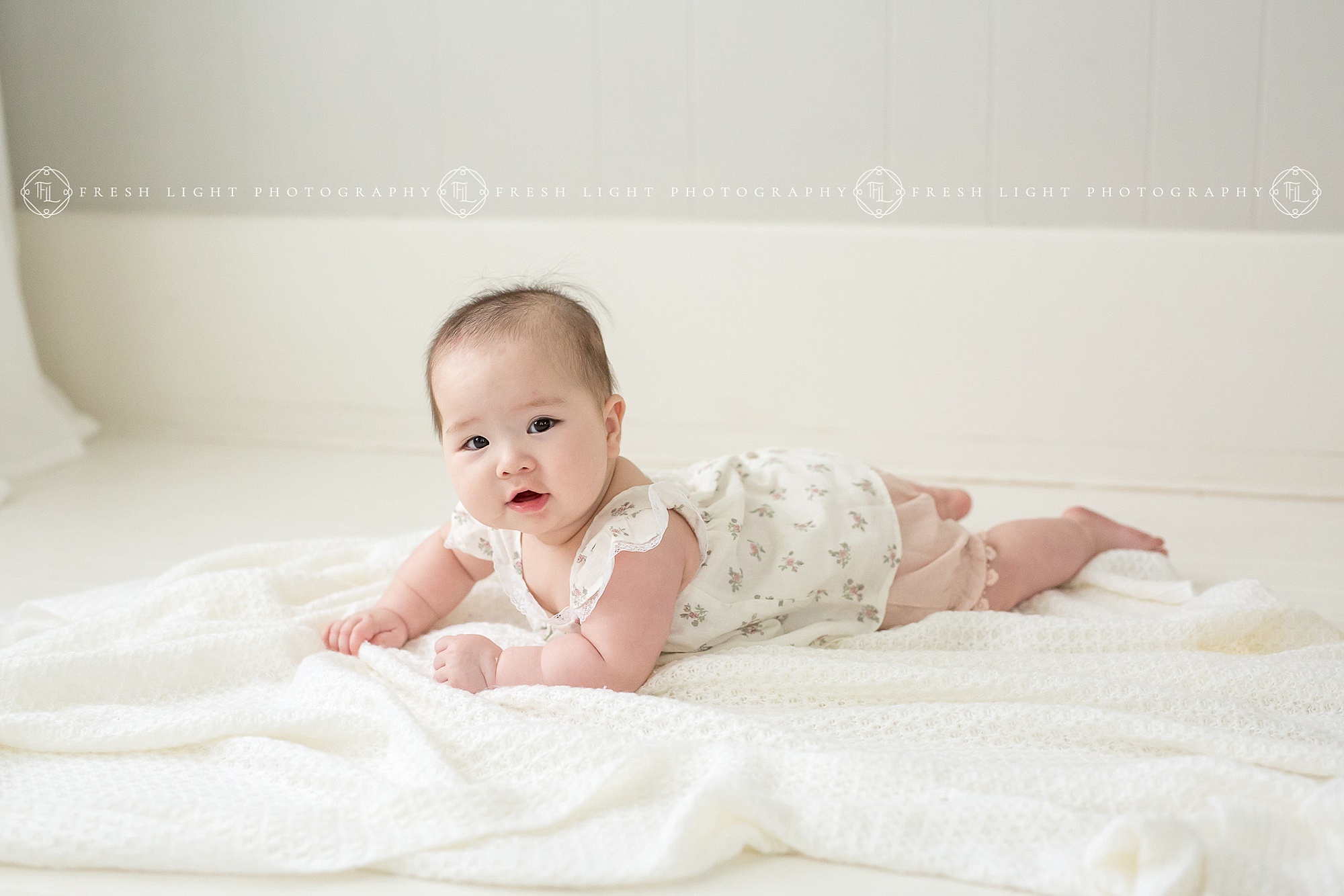 Baby girl laying on blanket in photography studio