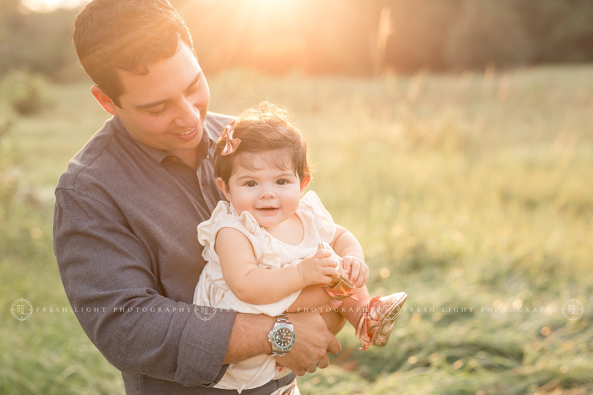 Dad holding daughter in outdoor setting