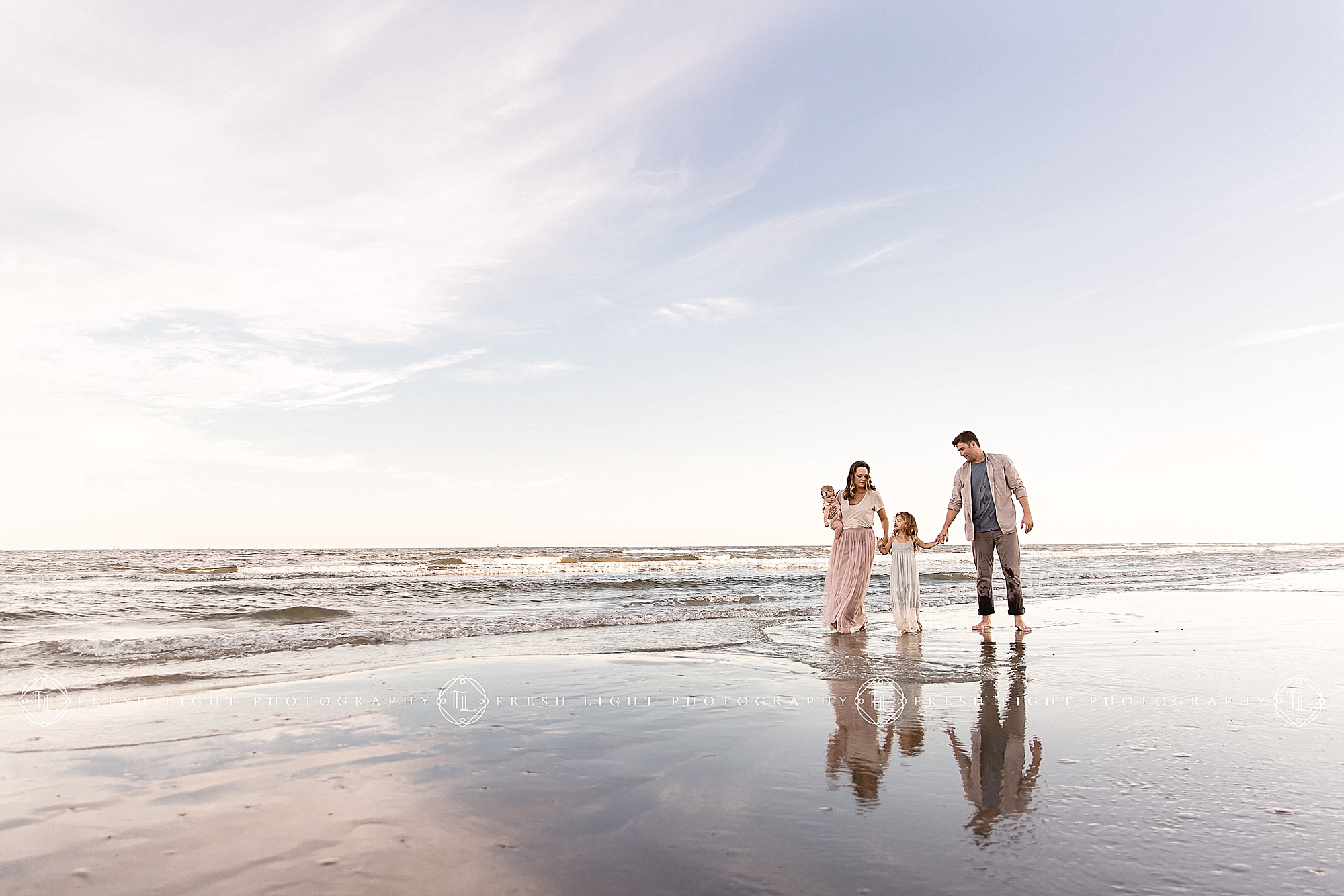 Family walking holding hands on the beach