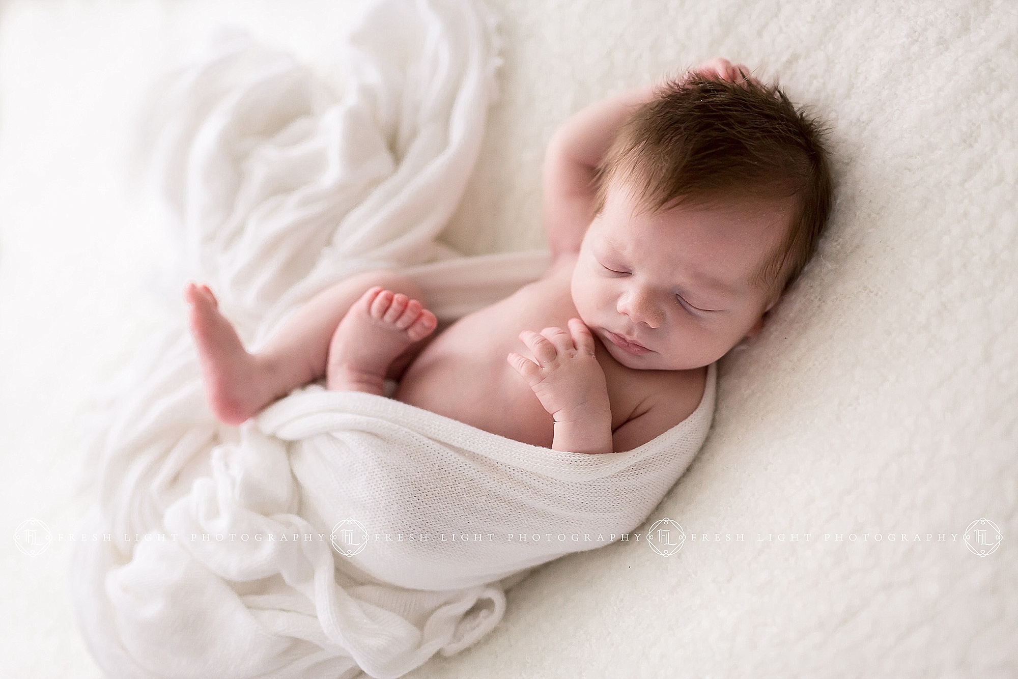 Newborn swaddled on bed