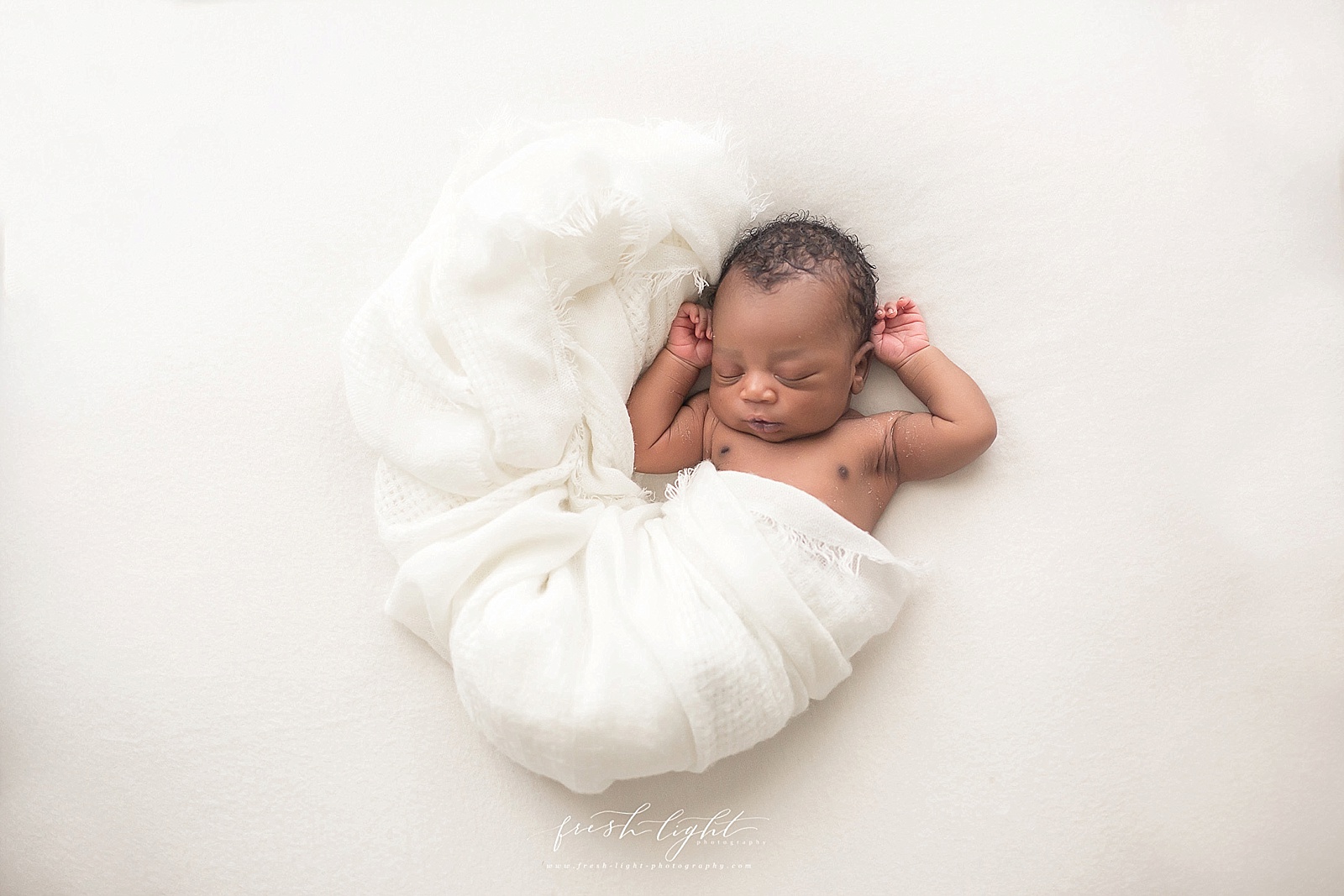 newborn swaddled in white blanket