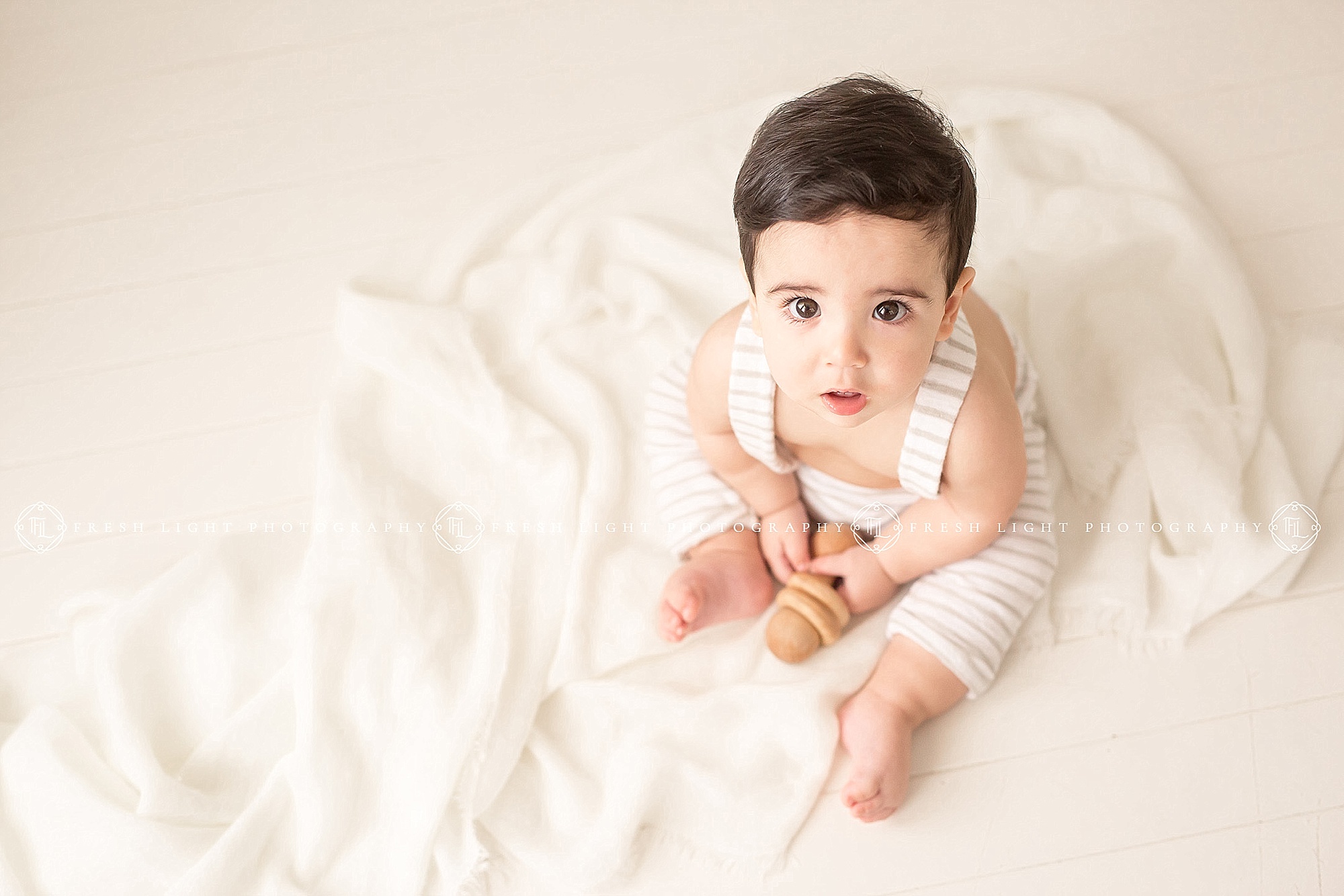 baby boy wearing white in natural light portrait session in houston