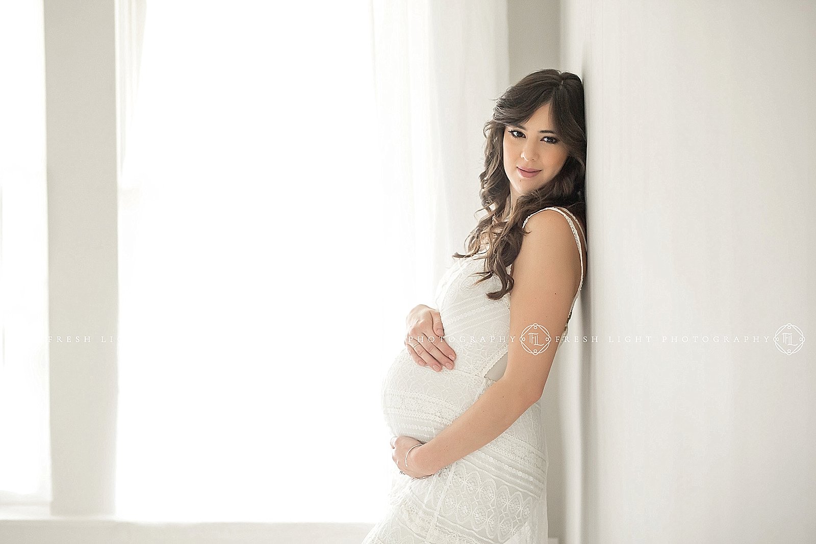 Pregnant mom in lace dress holding belly
