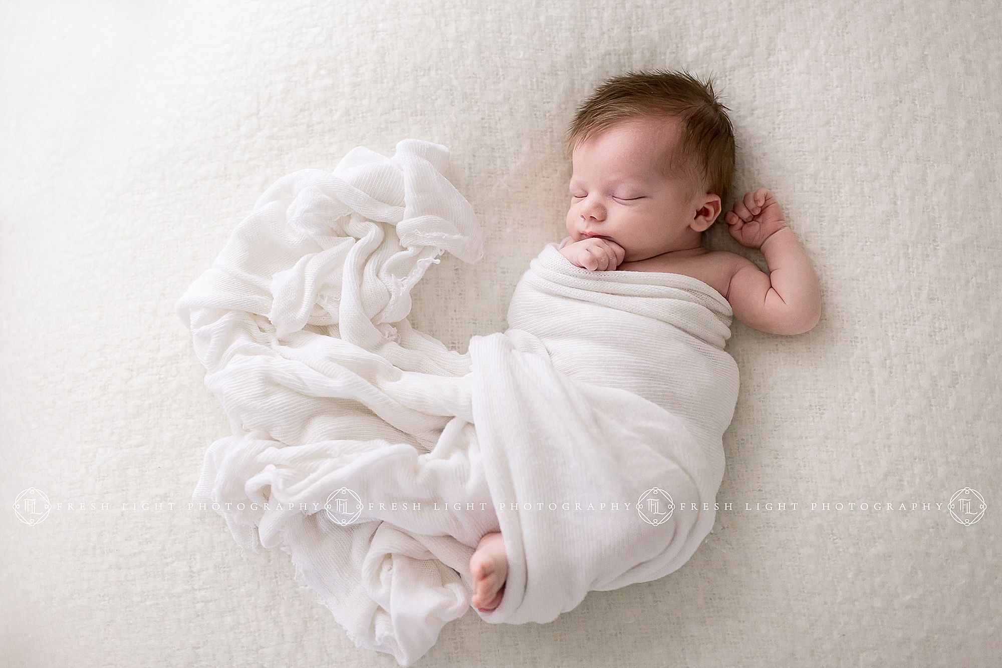 Newborn swaddled on blanket