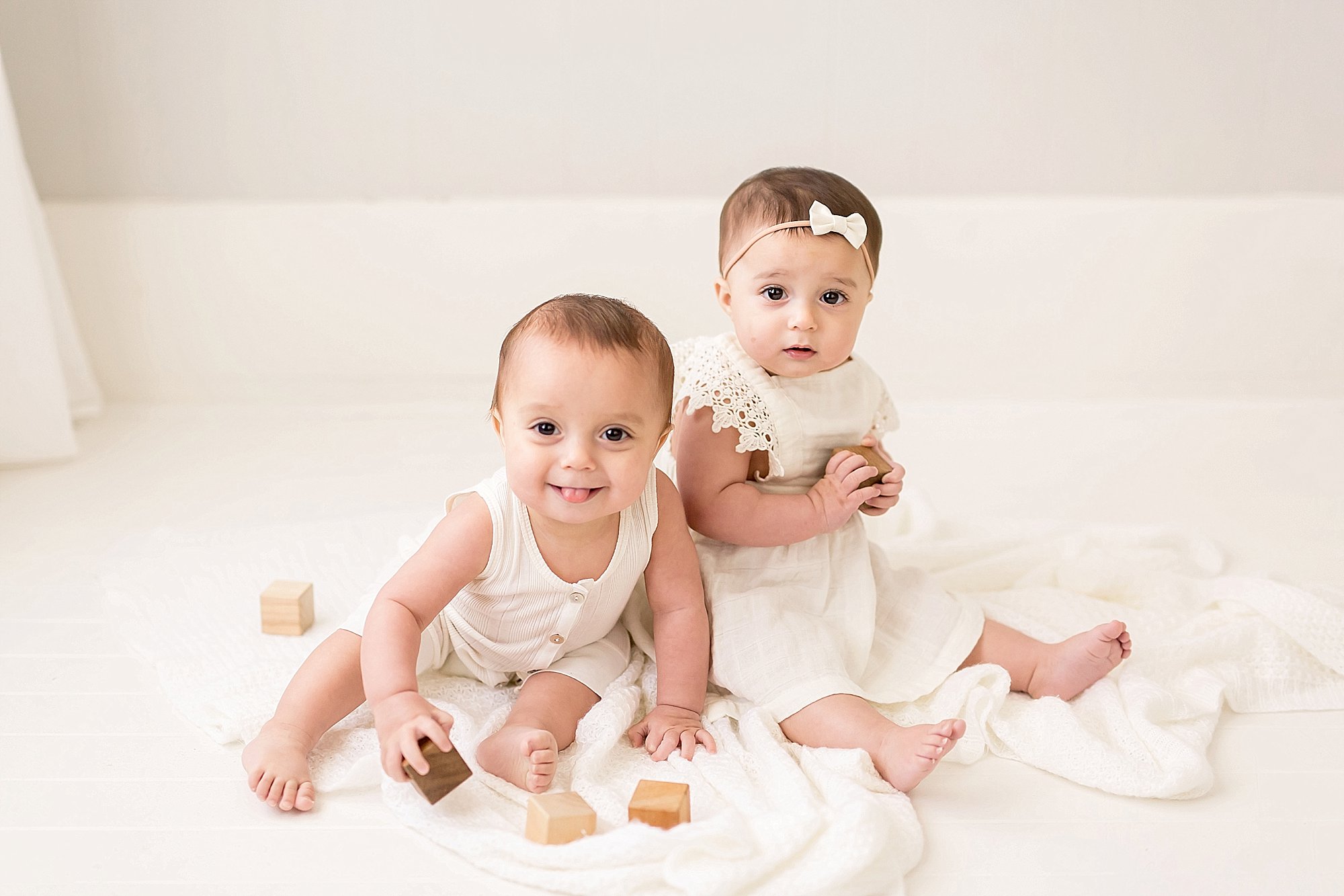 adorable twins sitting and playing with block