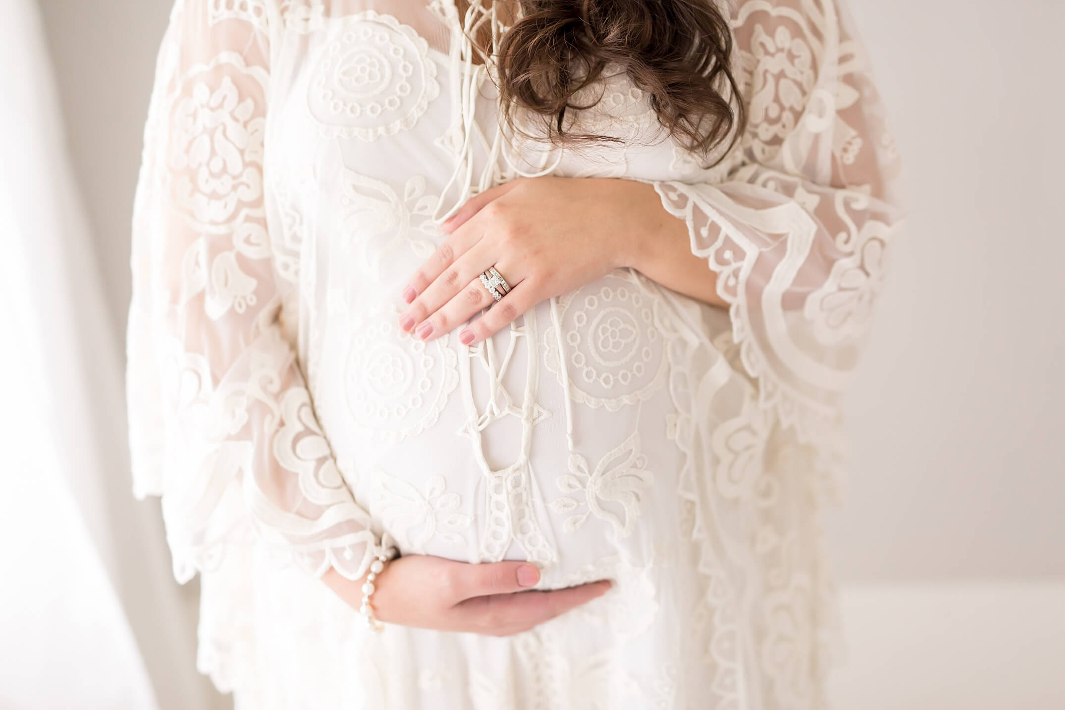 mom holding pregnant belly during studio maternity session in houston