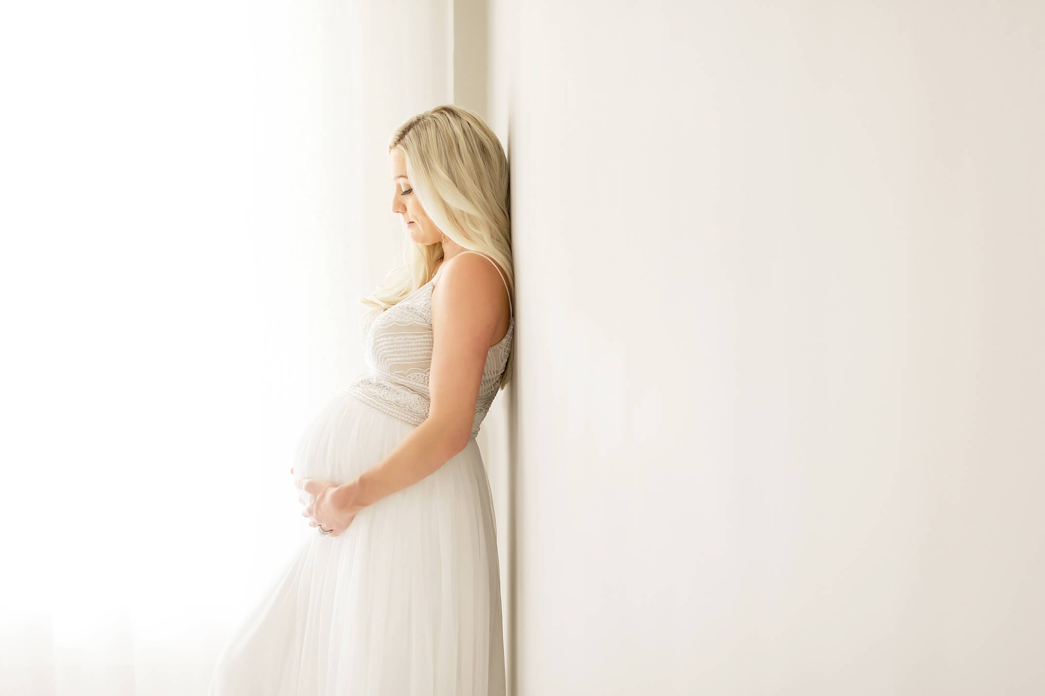 pregnancy session in heights studio with mom in white dress