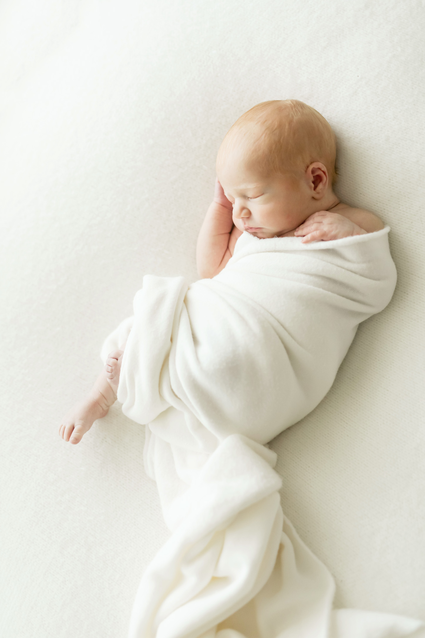 baby swaddled in white blanket