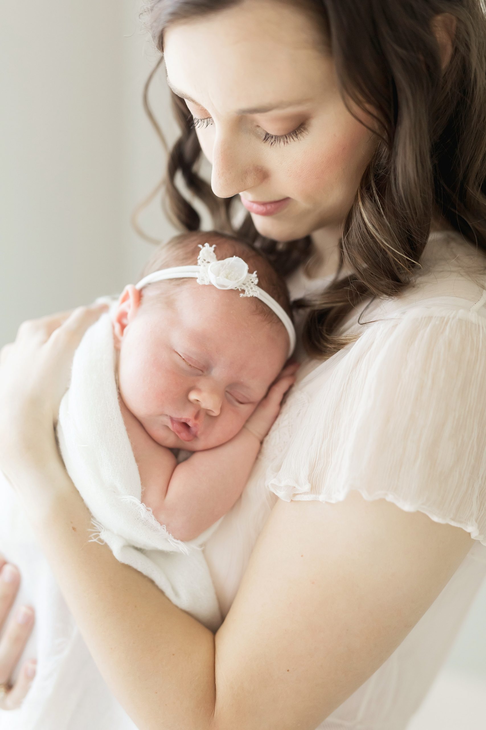 mom cuddling baby for newborn pictures