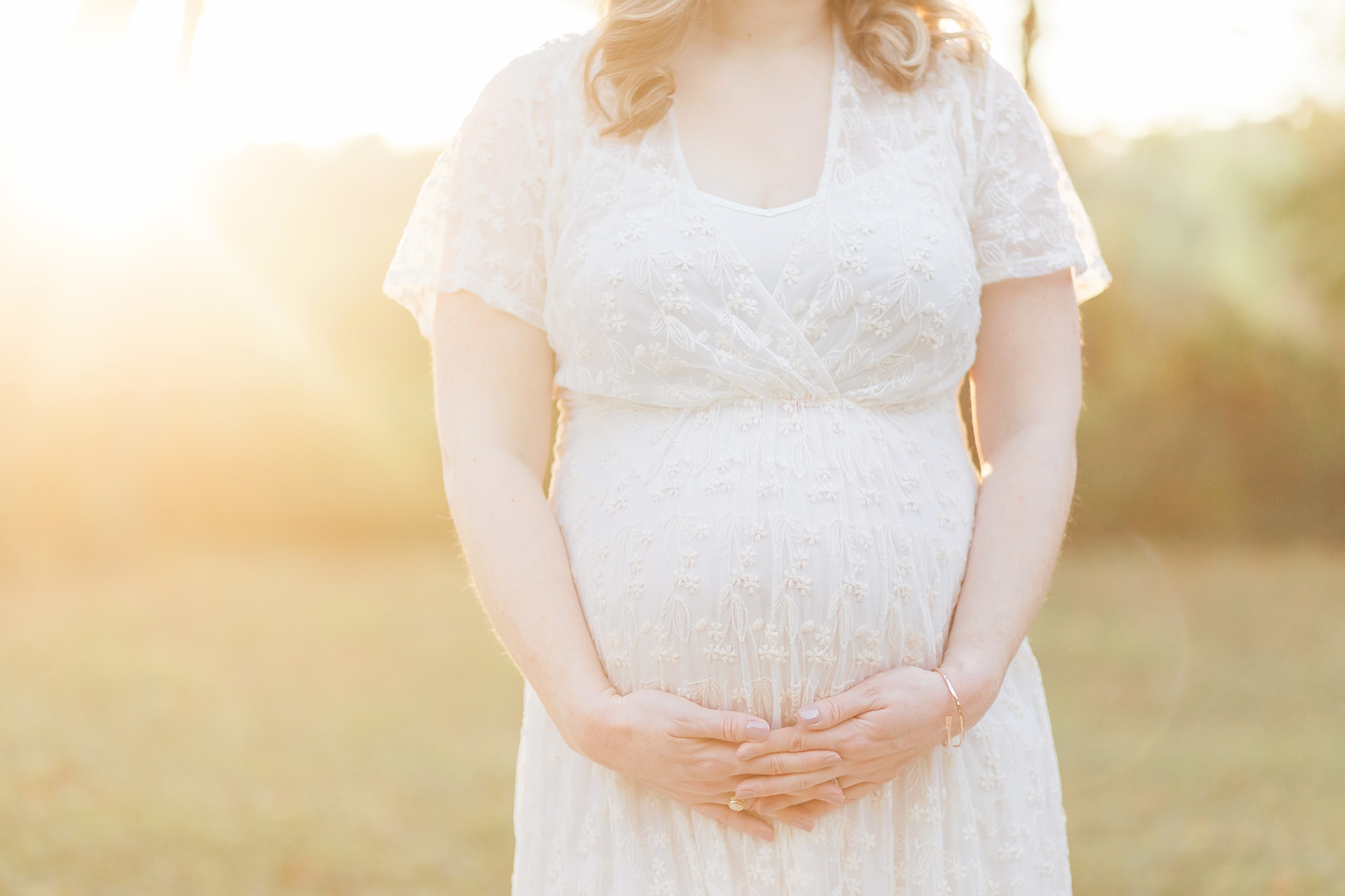 close up of pregnant mom in white dress