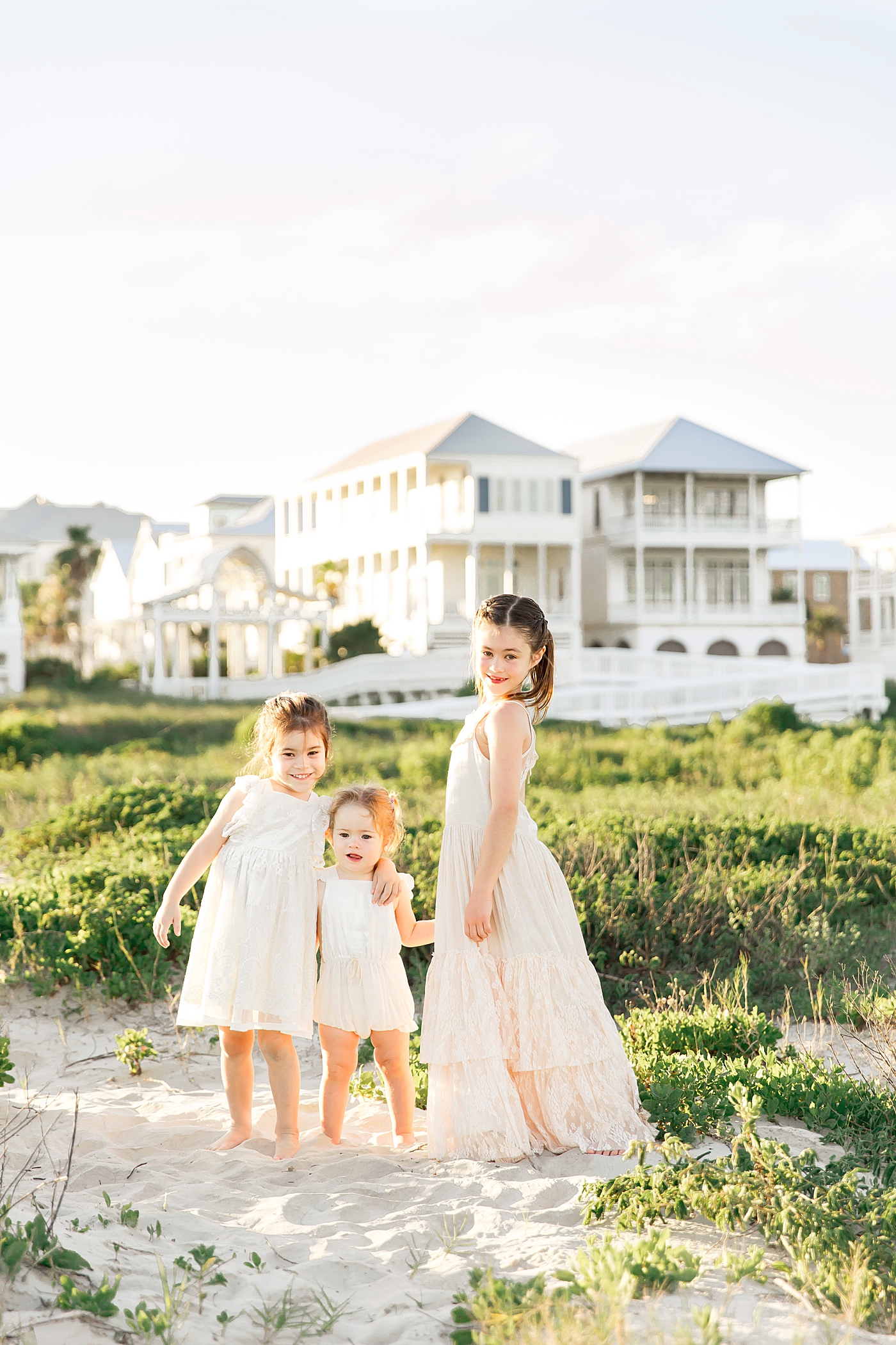 Three sisters standing together on the beach in Galveston. Photos by Fresh Light Photography.
