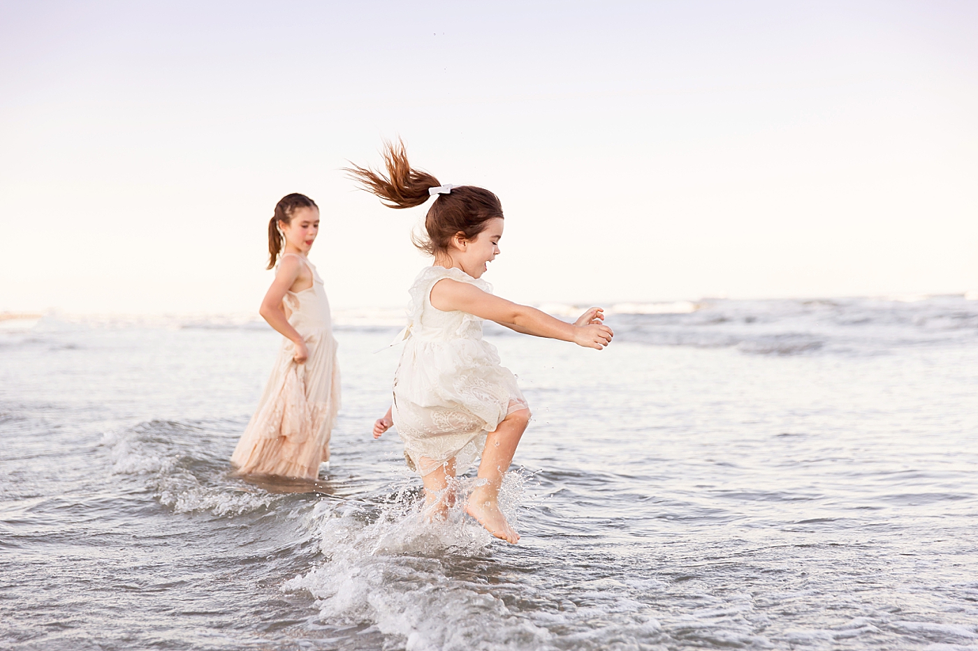 Three sisters having fun playing in the waves at Galveston Beach. Photos by Fresh Light Photography.