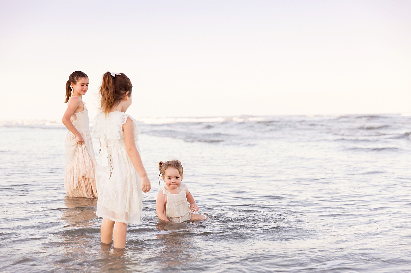 Three sisters having fun playing in the waves. Photos by Fresh Light Photography.