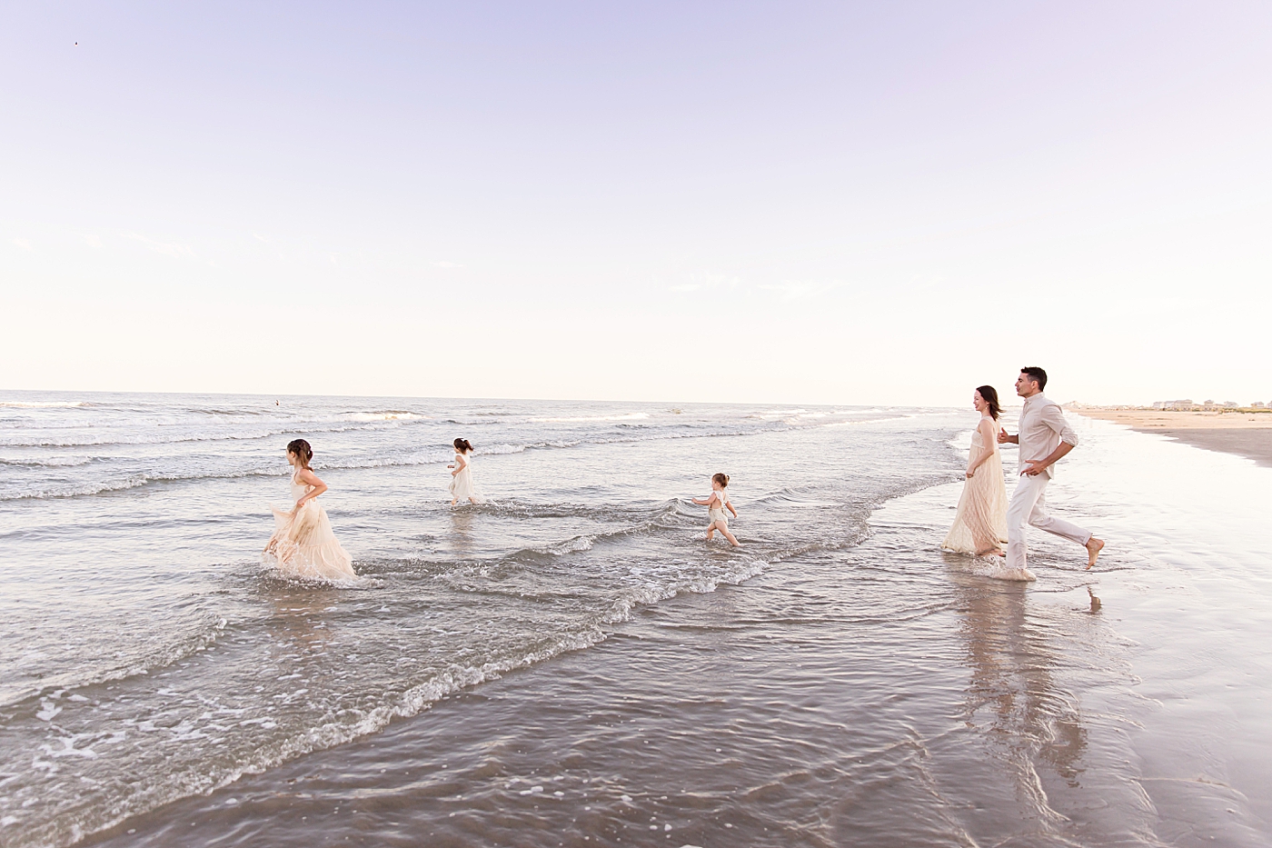 Family of five running into the ocean. Photos by Fresh Light Photography.