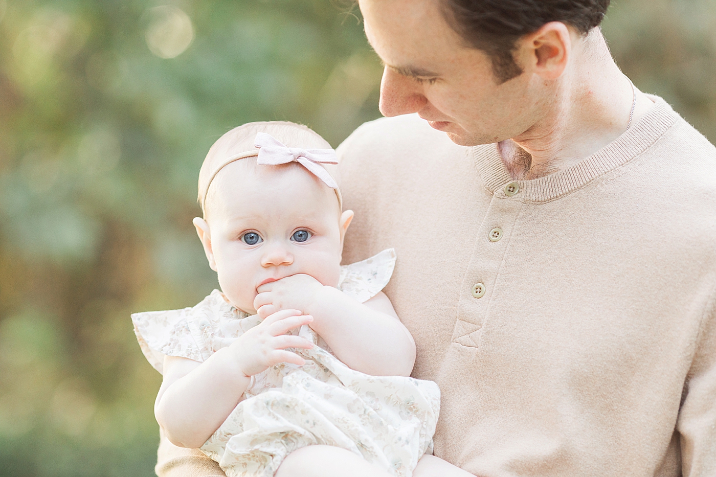 Baby girl with beautiful blue eyes being held by her Daddy. Photos by Fresh Light Photography.