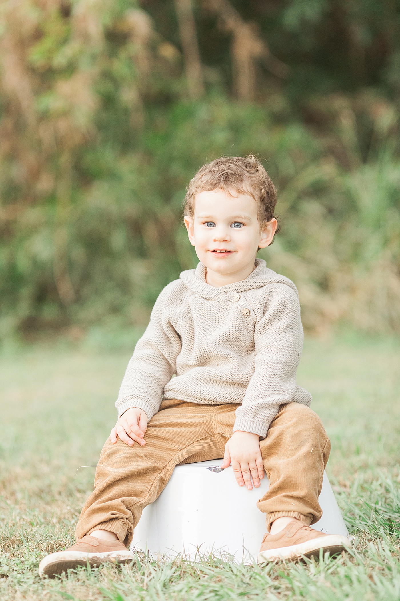 Toddler sitting in a field for family photos | Fresh Light Photography