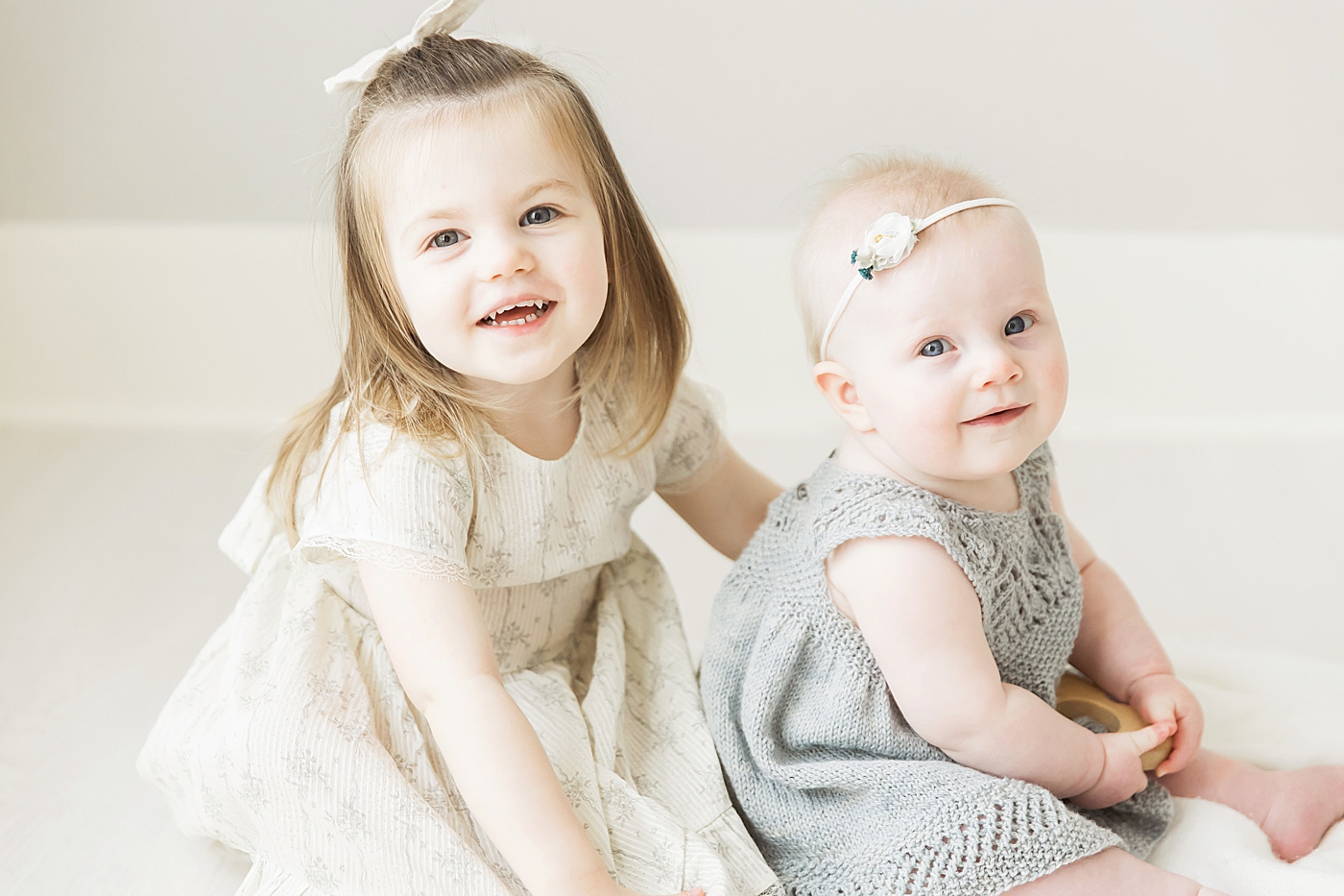 Big sister and little sister sitting together. Photos by Fresh Light Photography.