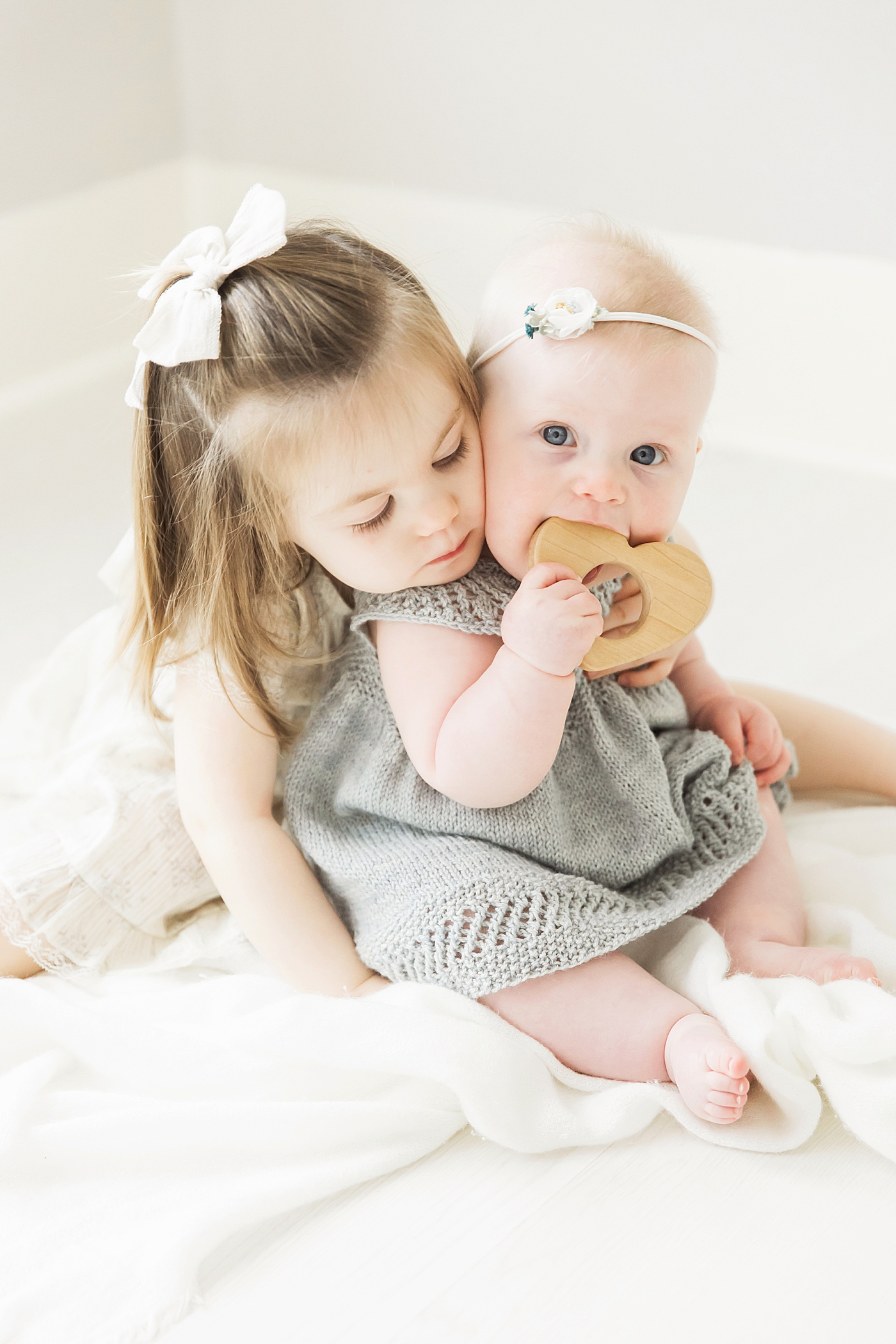 Big sister giving her baby sister a hug. Such a sweet moment photographed by Fresh Light Photography.