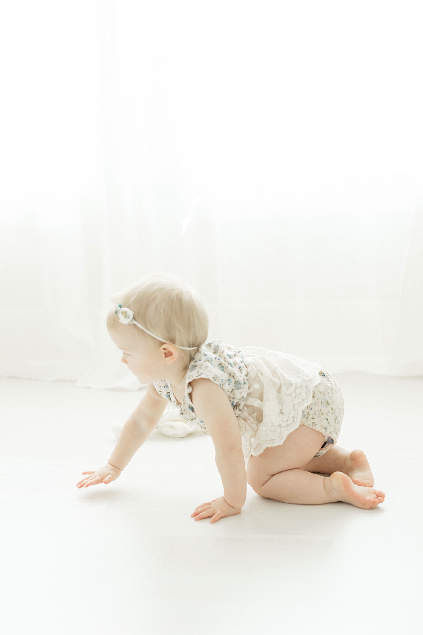 Baby crawling in white studio. Photo by Fresh Light Photography.