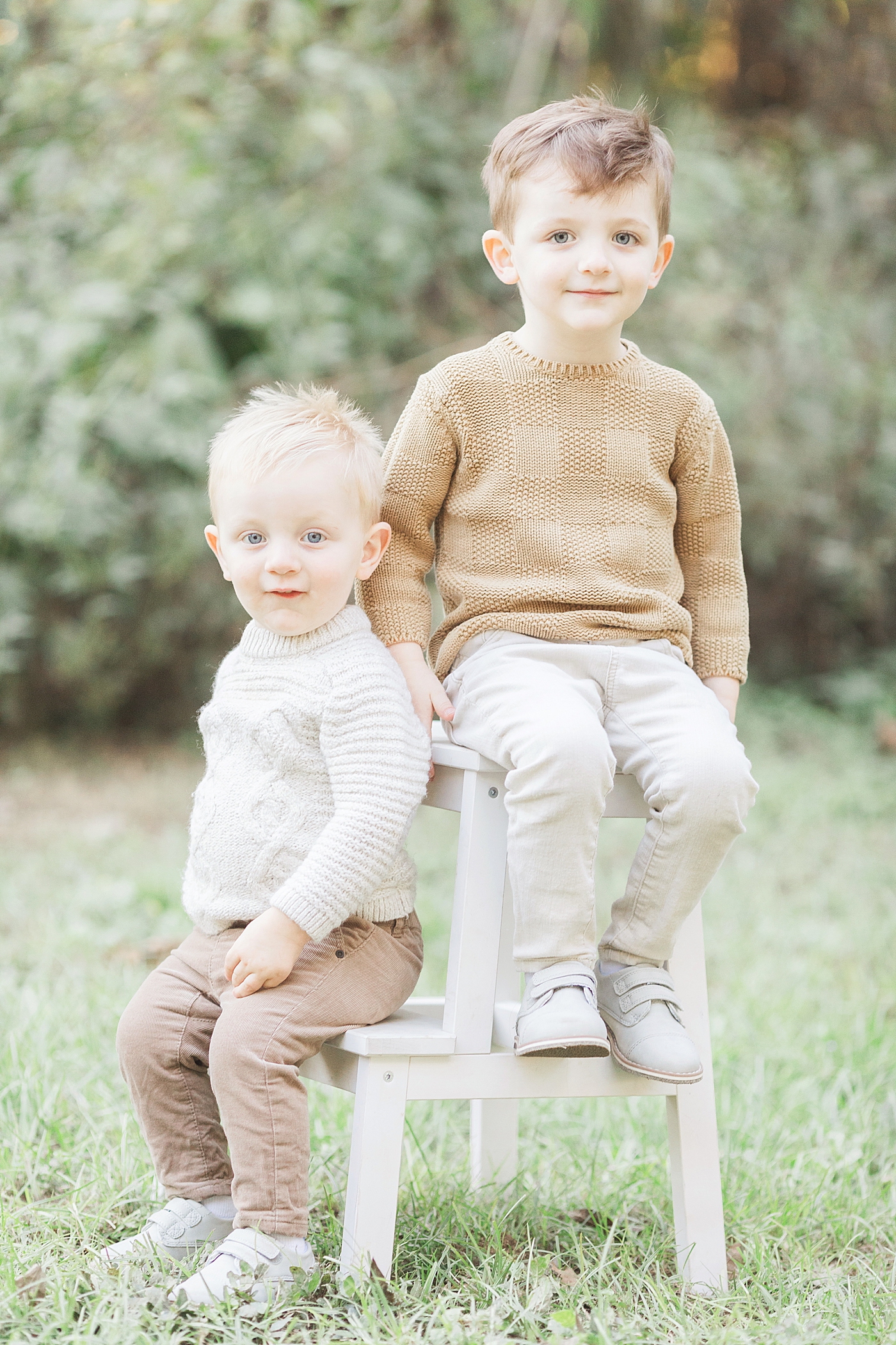Two brothers sitting on a stool for family photos with Fresh Light Photography.