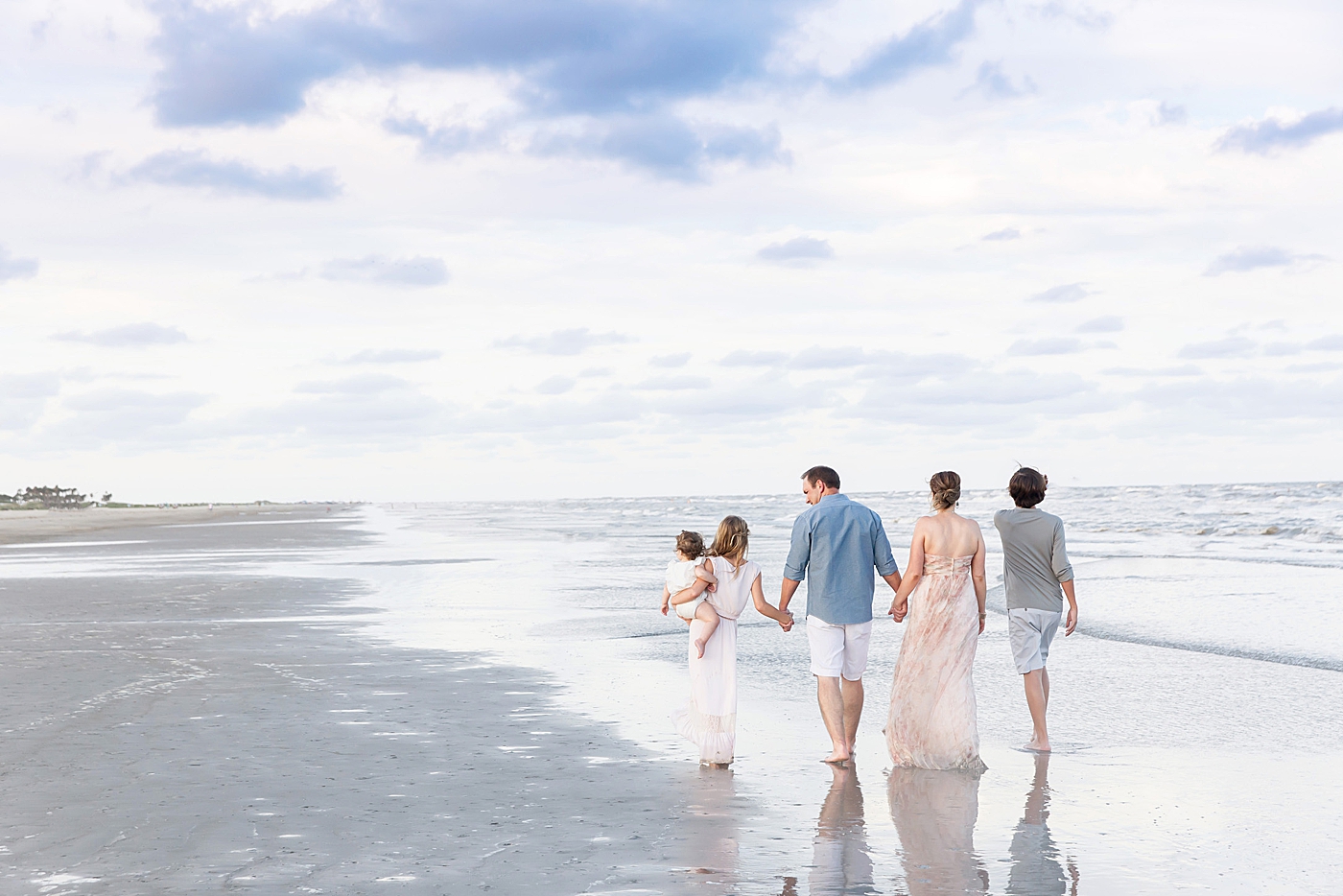 Family walking on the beach holding hands. Photo by Fresh Light Photography.