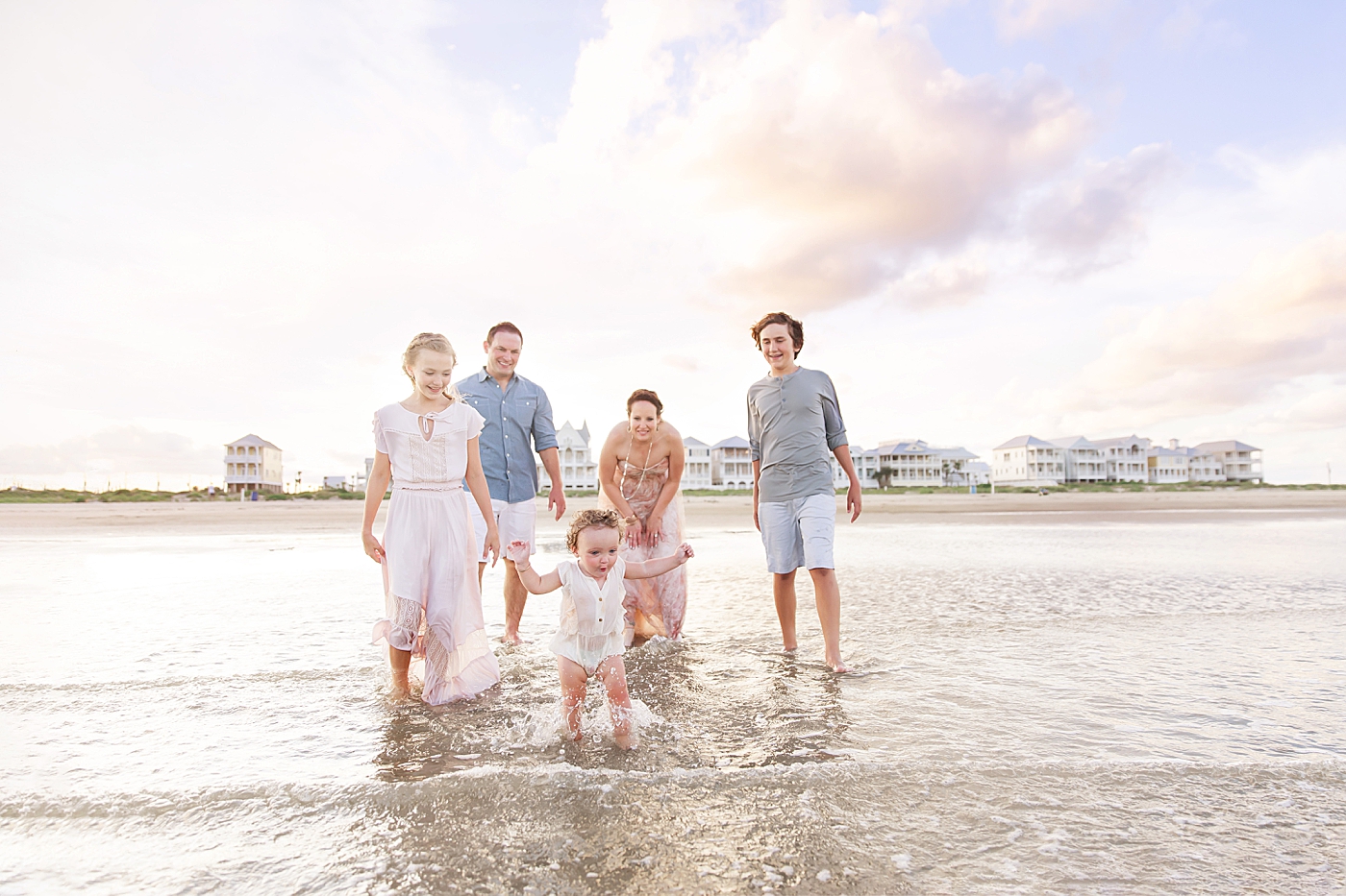 Family running into the ocean during family photoshoot on Galveston with Fresh Light Photography.