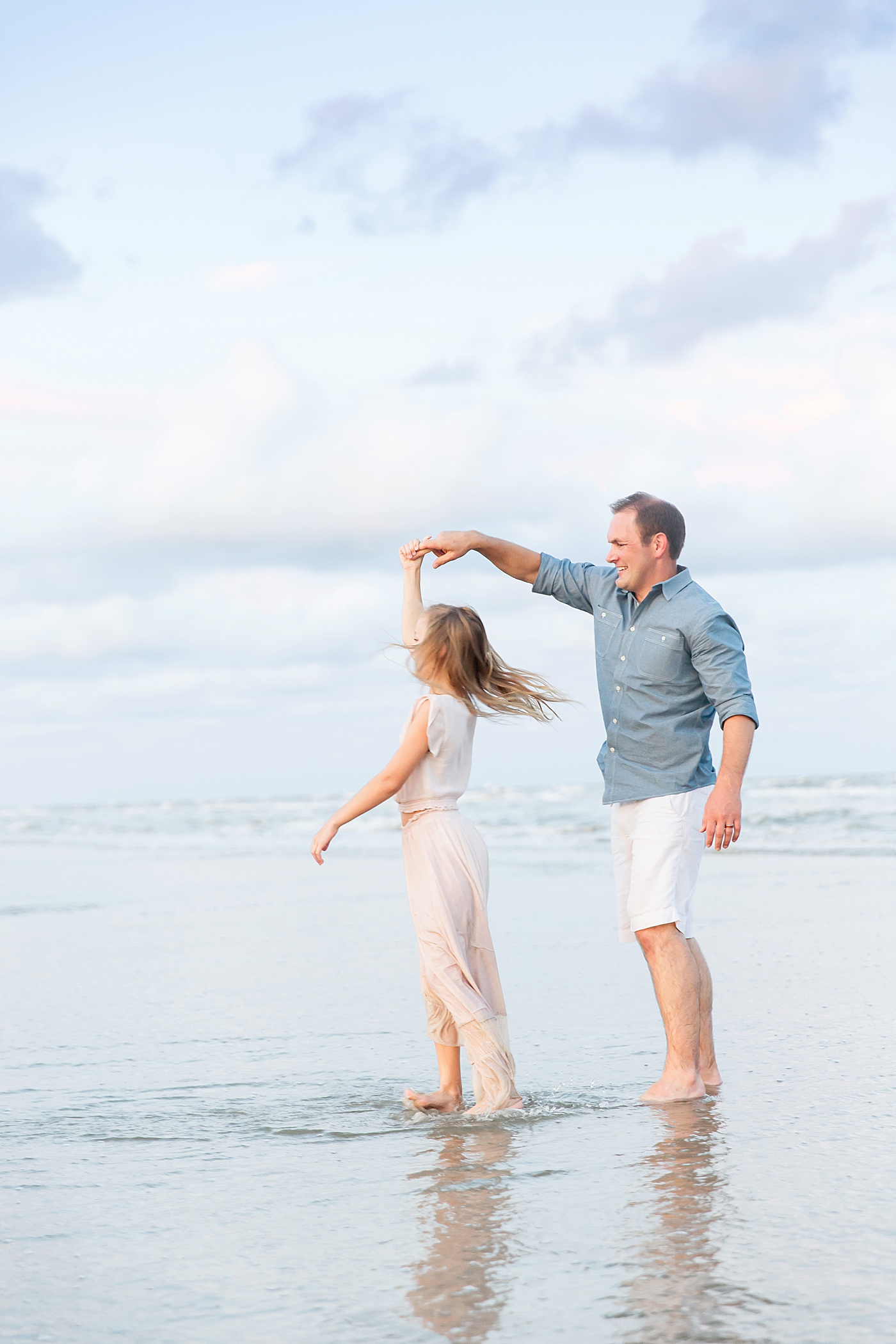 Dad dancing with his daughter on the beach. Photo by Fresh Light Photography.