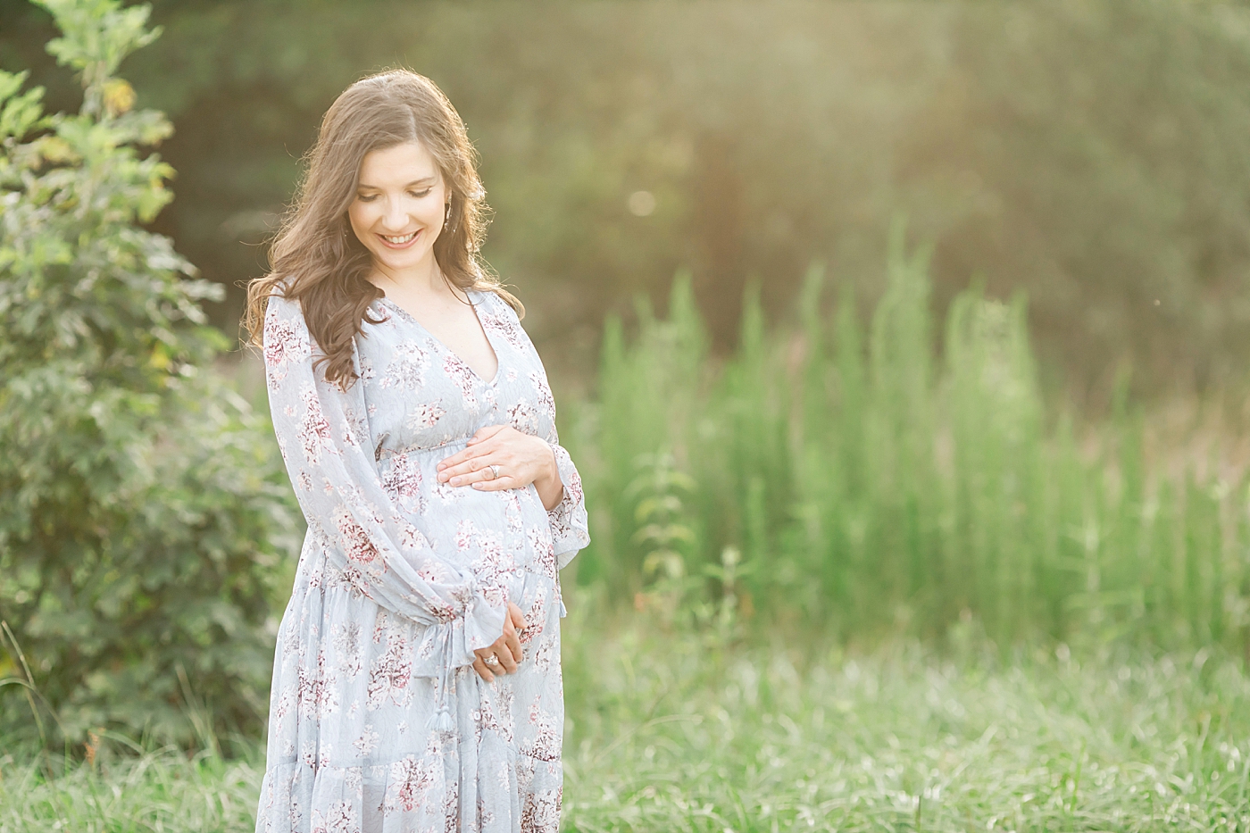 Maternity photo of mom in beautiful blue and floral dress. Photo by Fresh Light photgoraphy.