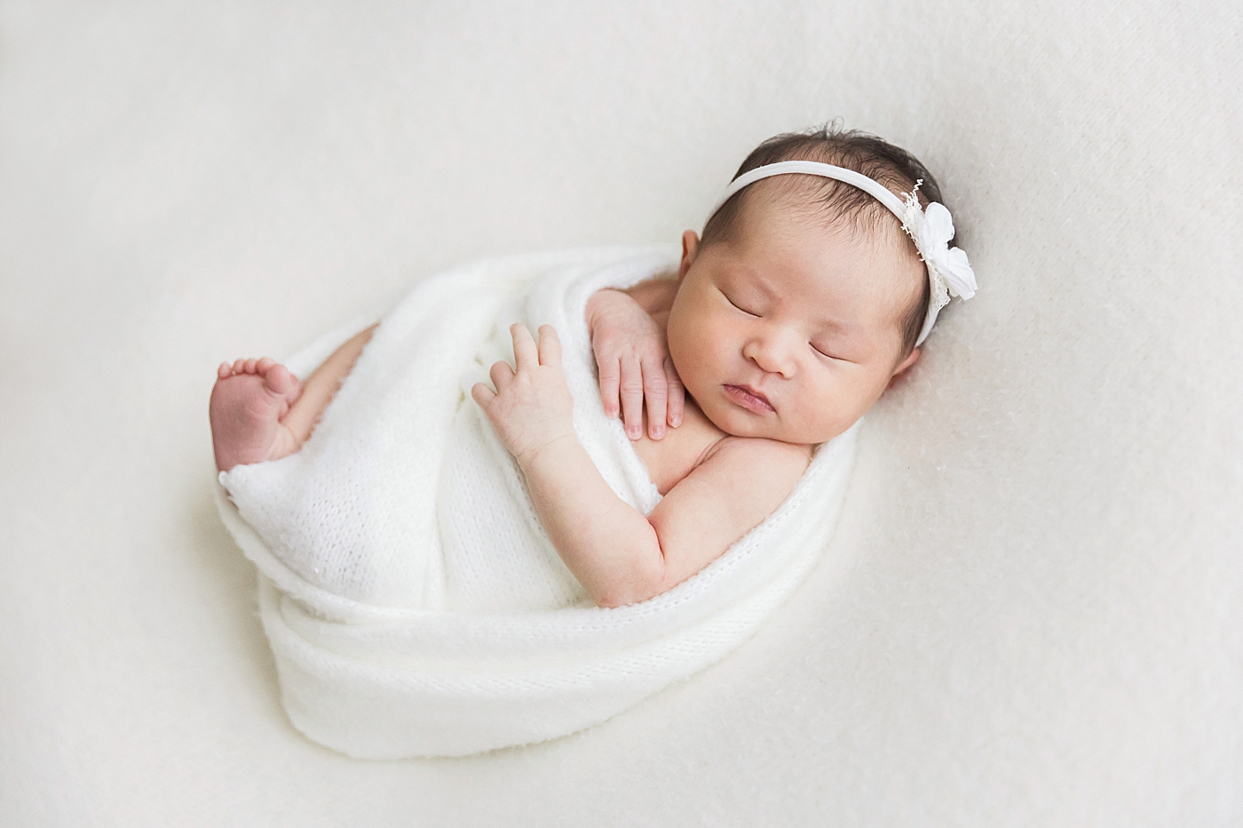 Classic newborn photo of baby girl swaddled in white. Photo by Fresh Light Photography.