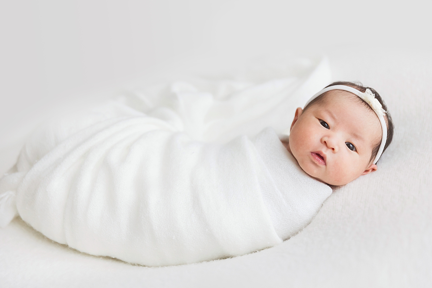 Baby girl wide away for professional newborn photography photos with Fresh Light Photography.
