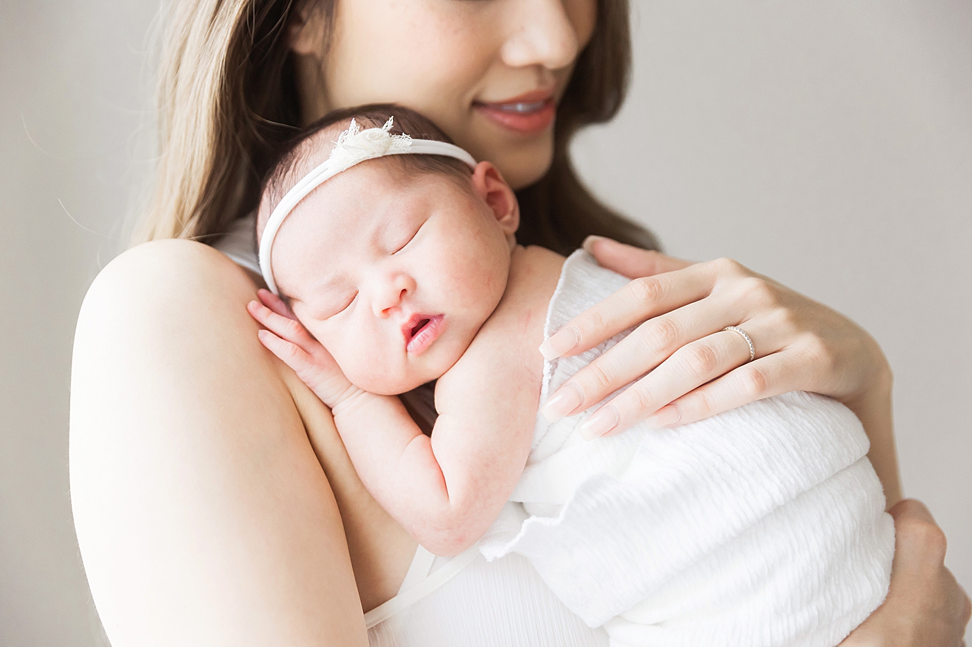 Baby girl laying with her head on moms shoulder. Photo by Fresh Light Photography.