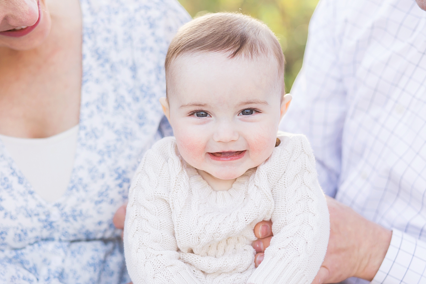 Six-month old baby boy smiling for family portraits. Photo by Fresh Light Photography.
