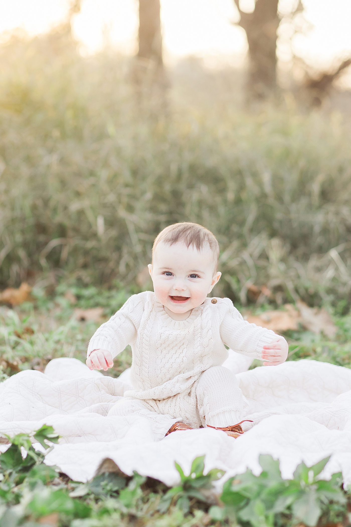 Six month old baby boy sitting on blanket in field during family photos. Photo by Fresh Light Photography.