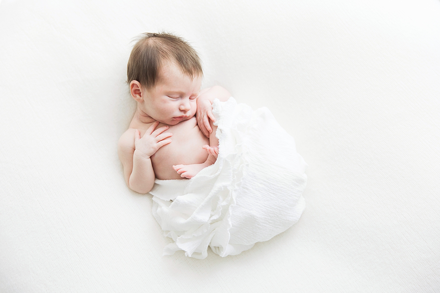 Newborn swaddles in white. Photo by Fresh Light Photography.