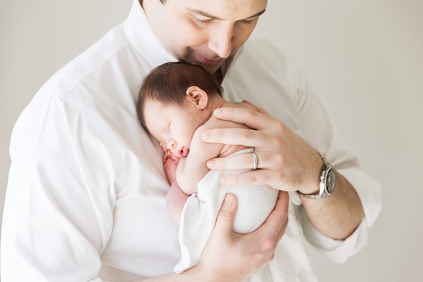 Newborn baby girl snuggled up on Dad's chest. Photo by Fresh Light Photography.