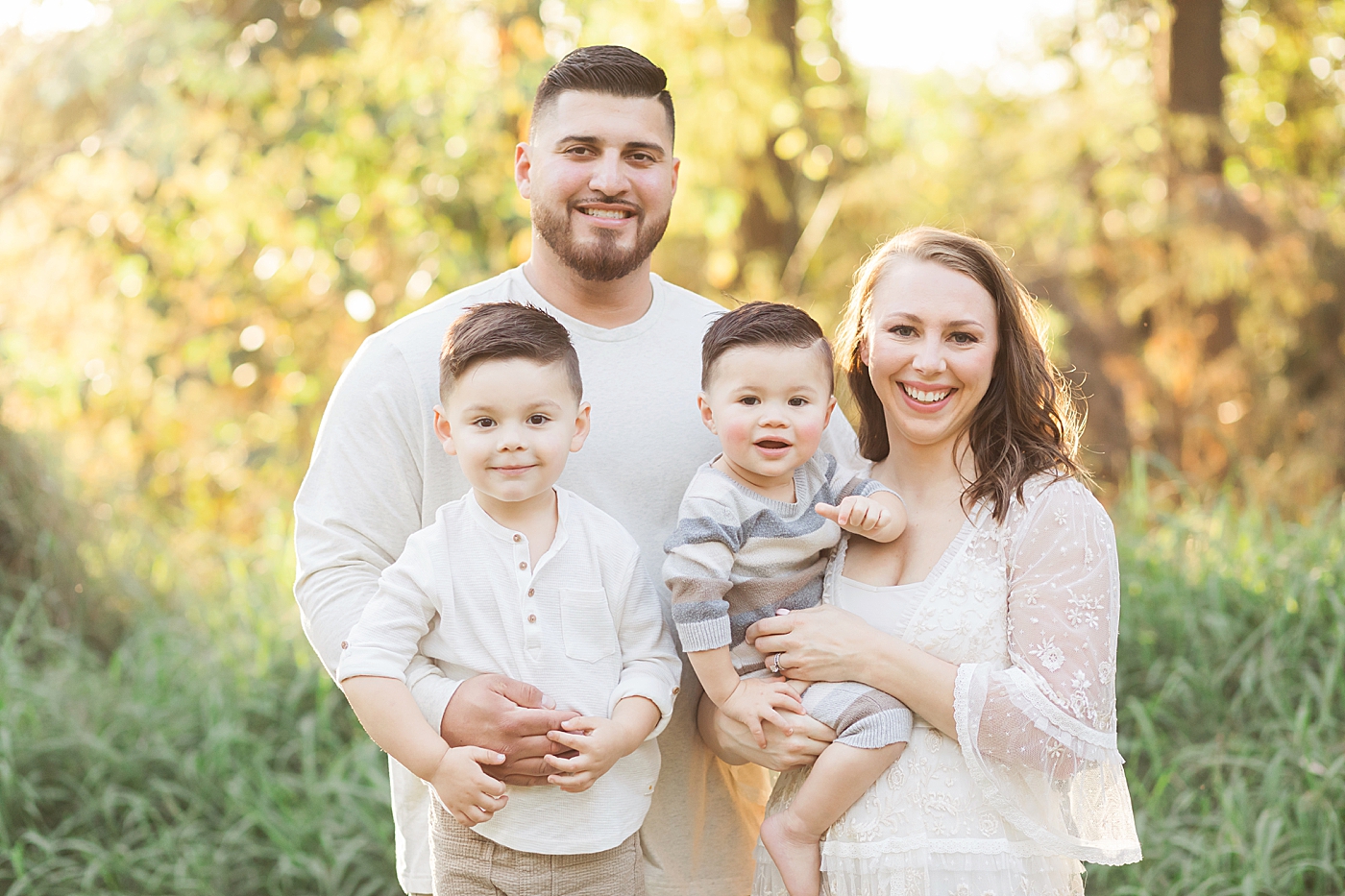 Mom, Dad and two boys smiling for family portrait with Houston family photographer, Fresh Light Photography.