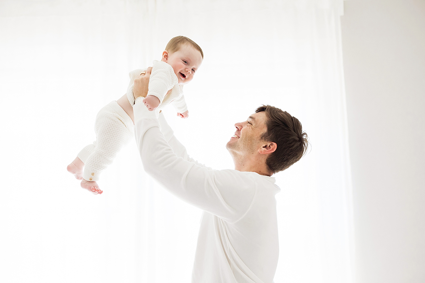 Dad holding son up in the air playing "airplane." Photo by Fresh Light Photography