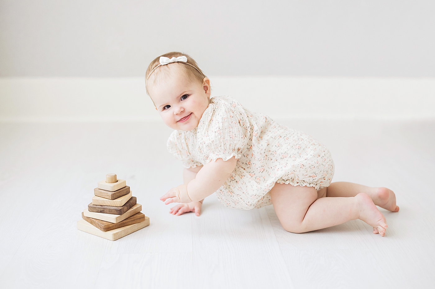 One year old baby girl playing during first birthday photoshoot with Fresh Light Photography.