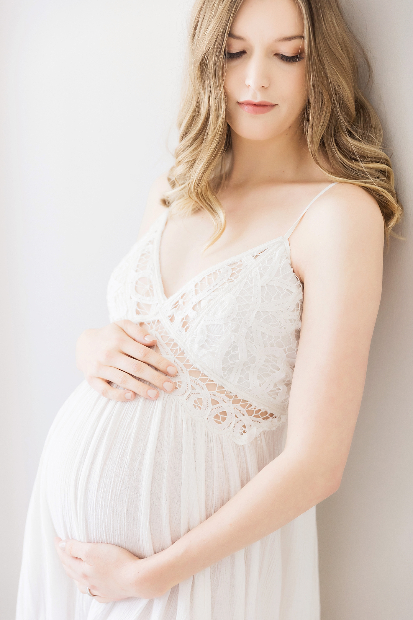 Mom in white lace dress for pregnancy photos. Photo by Fresh Light Photography.