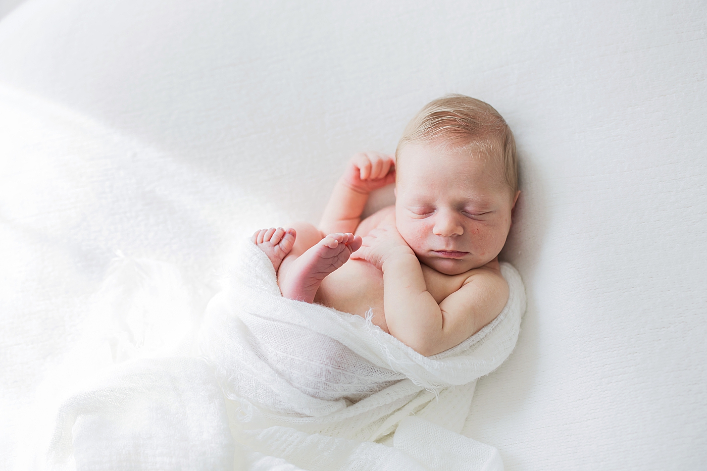 Newborn curled on back and sleeping. Photos by Fresh Light Photography.