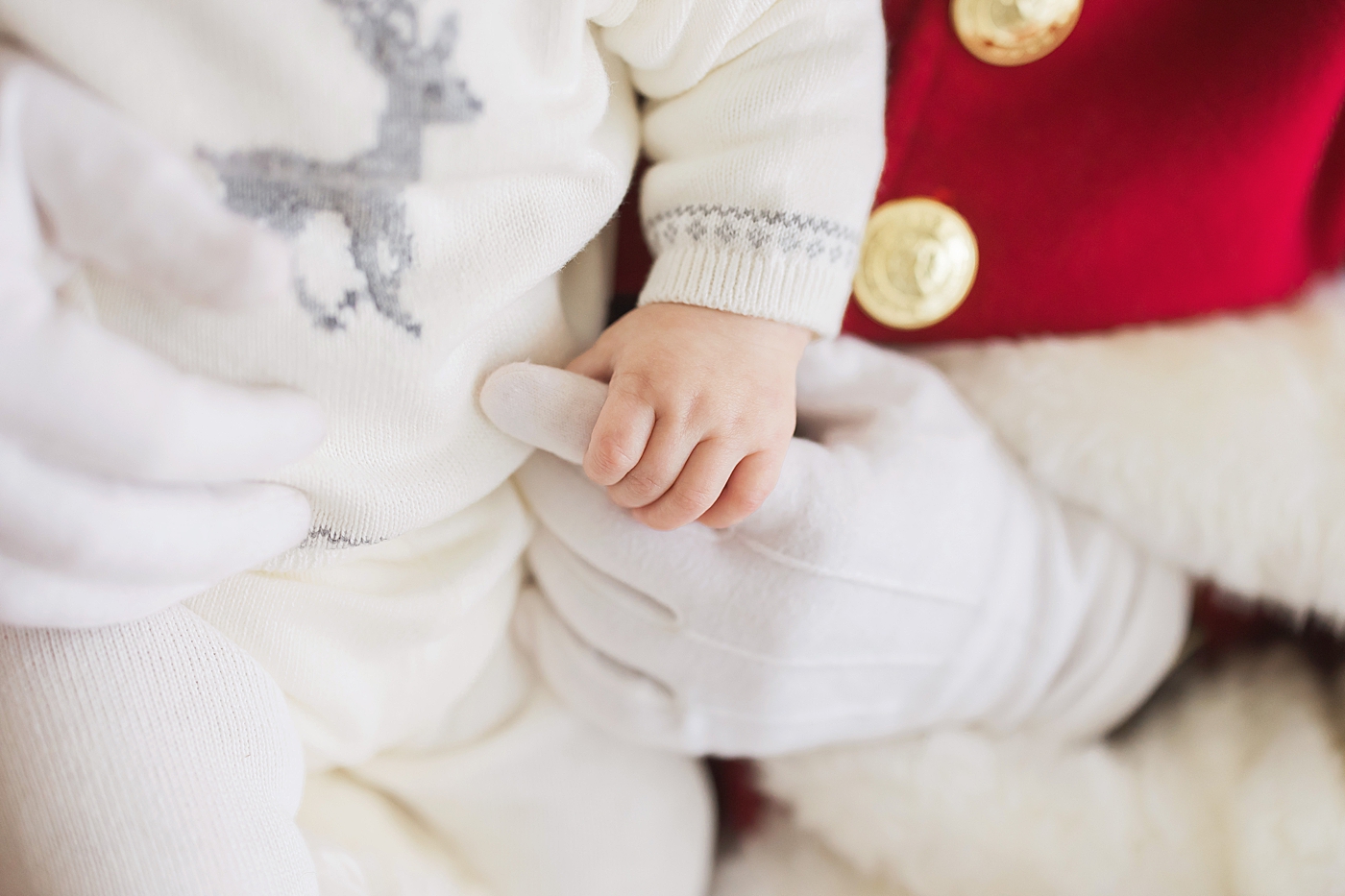 Baby holding Santa's finger. Photo by Fresh Light Photography.