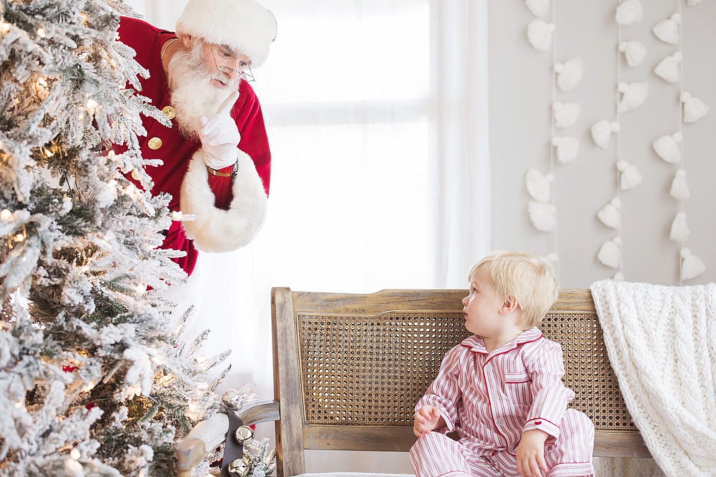 Little boy sees Santa hiding behind tree! Photo by Fresh Light Photography.