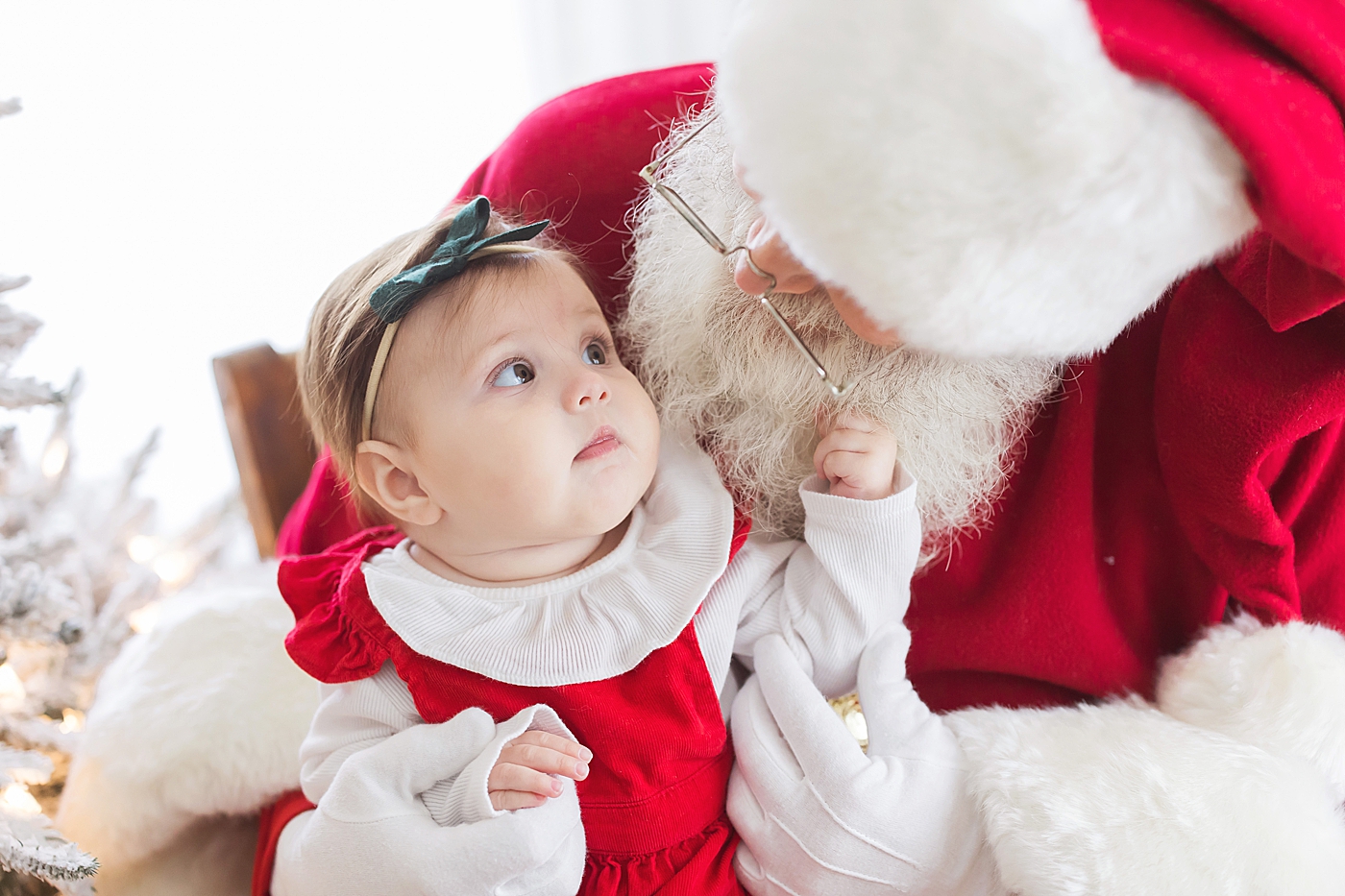 Baby girl pulling on Santa's beard. Photo by Fresh Light Photography.